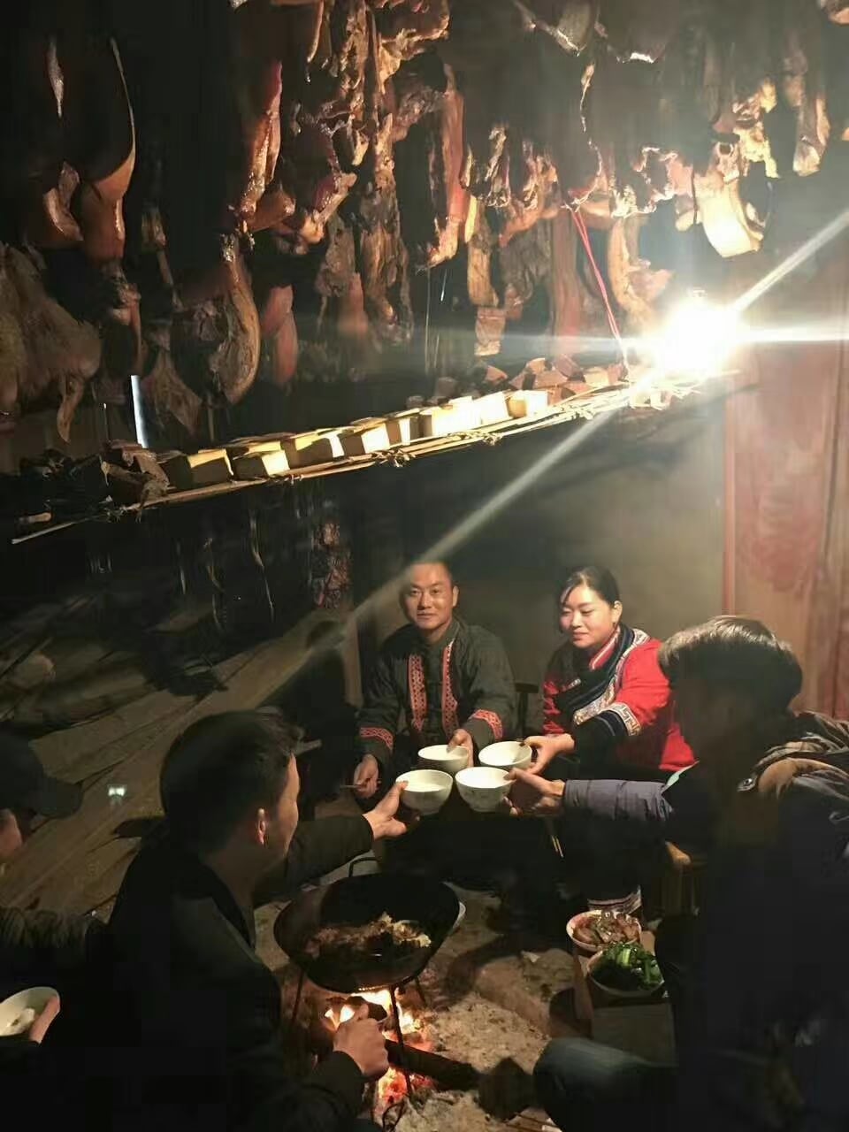 人们围着火塘吃饭